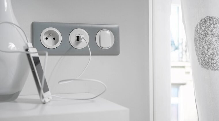 un mur avec prise électrique, prise USB et interrupteur
